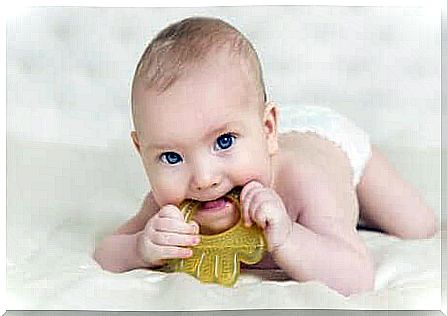 A baby biting a rattle. 