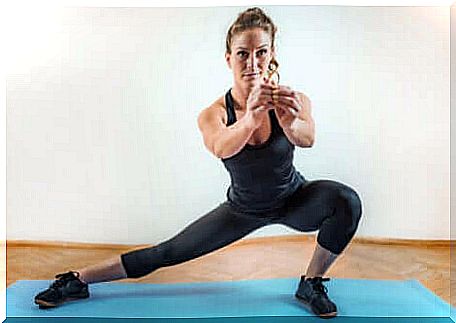 A woman doing a lateral squat. 