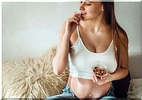 Pregnant woman eating almonds after dinner.