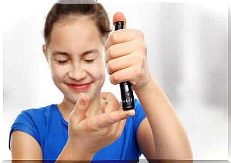 A young girl taking her blood sugar using an insulin pen. 